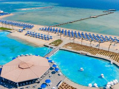 Grand complexe avec plusieurs piscines, parasols et accès direct à la plage.
