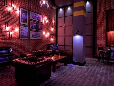 Cozy lounge with red brick walls, leather sofas, and dim lighting.