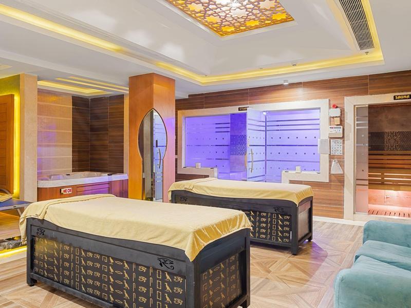 Chambre de spa moderne avec tables de massage et éclairage d'ambiance doux.