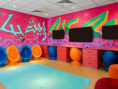 Colorful lounge area with spherical chairs and vibrant pink wall featuring abstract art.