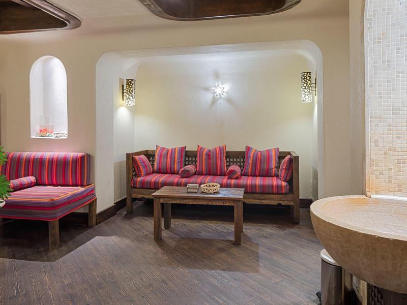Cozy sitting area with striped cushions, wooden table, and soft lighting in a hotel lounge.
