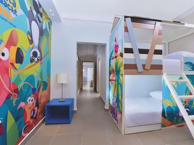 Couloir d'hôtel coloré avec lits superposés et fresque murale animalière vivante.