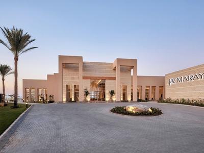 Ingresso moderno dell'hotel con palme e linee pulite al crepuscolo