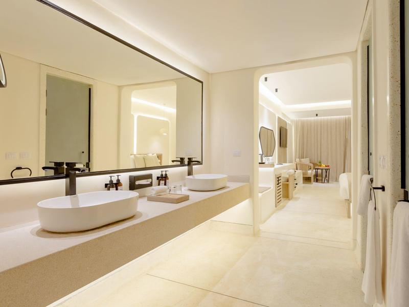 Moderne hotelbadkamer met dubbele wastafels en grote spiegel, helder en ruim.