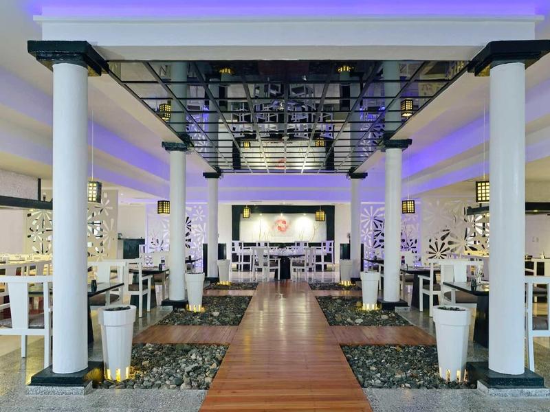 Prostorný hotelový vstup s bílými sloupy a mramorovými podlahami.