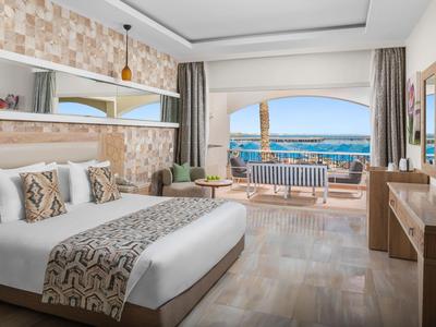 Modernes Hotelzimmer mit Doppelbett, Balkon und Meerblick.