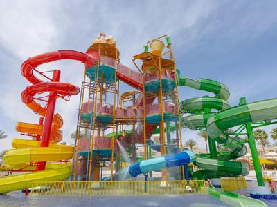 Bunte Wasserrutschen in Gelb, Rot, Grün und Blau mit Türmen und klarem Himmel im Hintergrund.