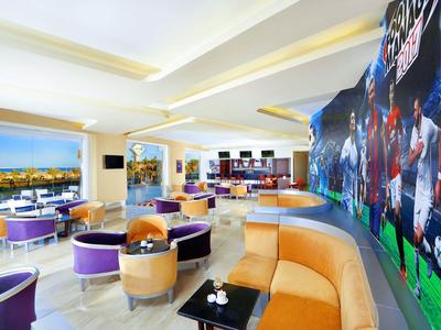 Moderne, kleurrijke hotel lounge met comfortabele zitplaatsen en grote sportmuur.