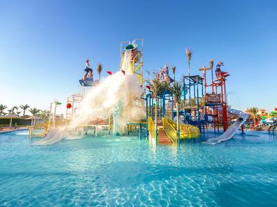 Bunter Wasserspielplatz mit Rutschen und Planschbecken unter blauem Himmel.