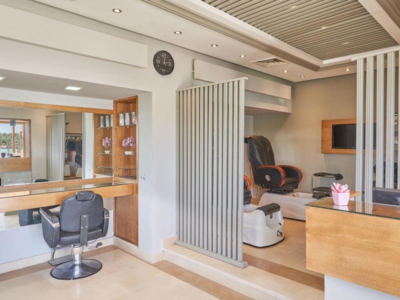 Innenraum eines modernen Friseursalons mit Stühlen, Spiegeln und entspannendem Massagesessel.