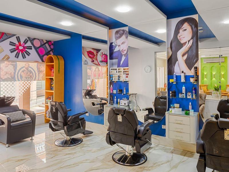 Friseursalon mit schwarzen Friseurstühlen, bunten Wandbildern und modernen Einrichtungselementen.