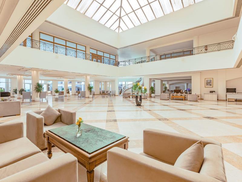 Helles, großzügiges Hotel-Lobby mit bequemen Sofas, Glastisch und Glasdach.