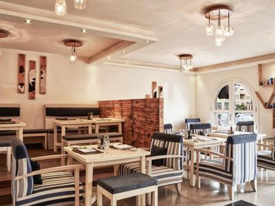 Bright restaurant with wooden tables, striped chairs, and large windows.