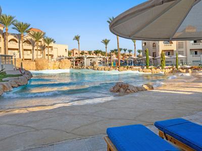 Piscina dell'hotel con lettini e ombrelloni in un resort soleggiato