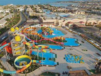 Aerial view of a large water park with many slides and pools next to a hotel complex.