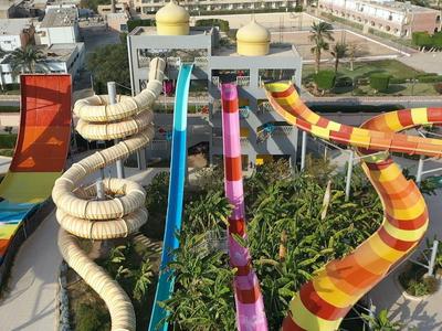 Bunte Wasserrutschen mit Kurven und Spiralen in einem Wasserpark bei strahlendem Sonnenlicht.