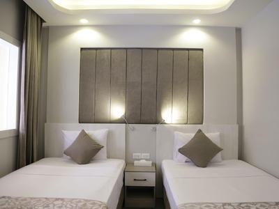 Camera d'hotel moderna con due letti singoli e un comodino in mezzo