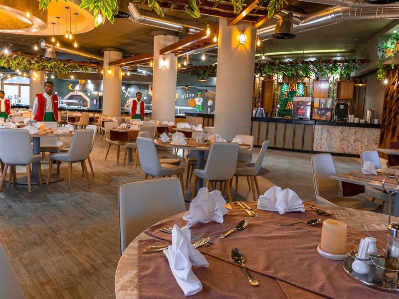 Elegantes Restaurant mit gedeckten Tischen, warmem Licht und moderner, gemütlicher Einrichtung.