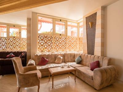 Cozy hotel lounge with sofas, armchairs, and warm wood decor.