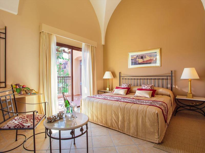 Cozy hotel room with double bed, two nightstands, and access to a balcony.