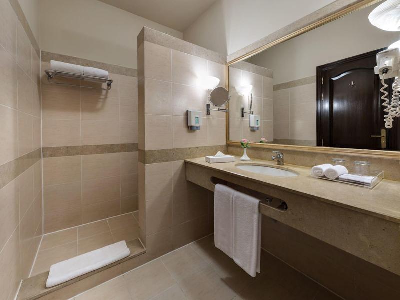 Modern hotel bathroom with walk-in shower and large mirror.