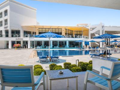 Moderner Außenbereich mit blau-weißen Stühlen und Sonnenschirmen an einem großen Pool.