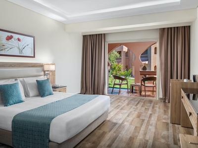 Modern eingerichtetes Hotelzimmer mit Doppelbett, Holzboden und Balkon mit Blick ins Grüne.