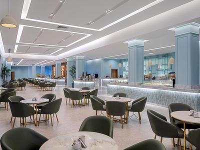 Elegancka restauracja hotelowa z nowoczesnymi stołami, krzesłami i subtelnym oświetleniem.