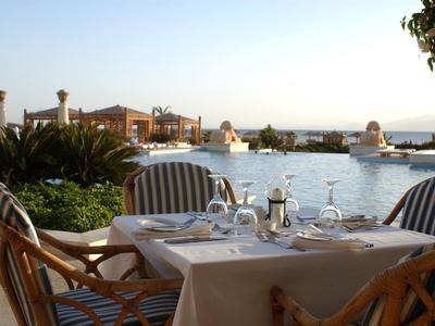 Blick auf Küstenstadt mit Sandstrand, Palmen, Gebäuden und klarem blauem Himmel.