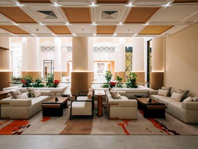 Moderne Hotellobby mit eleganten Sofas, Teppichen und dezenter Beleuchtung.