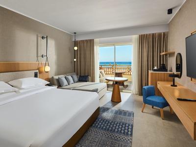 Modernes Hotelzimmer mit Doppelbett, Balkon und Meerblick.