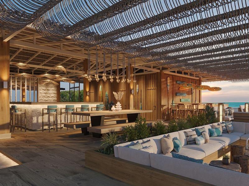 Moderner Strand-Pavillon mit Holzdecke, Lounge-Bereich, Bar und Meerblick bei Sonnenuntergang.