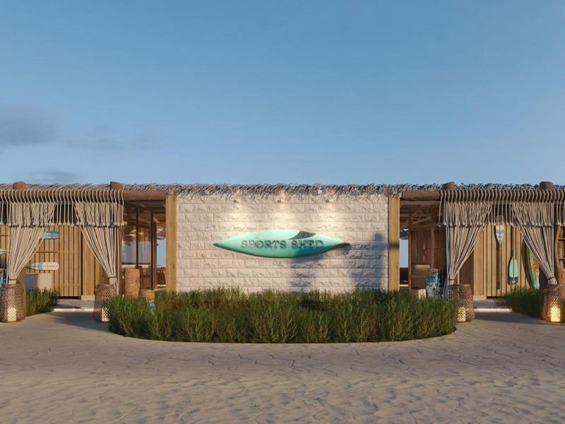 Modernes, einstöckiges Hotelgebäude mit Holzverkleidung und Logo in der Mitte vor blauem Himmel.