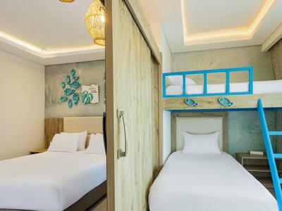 Hotelzimmer mit Doppelbett und Etagenbett, modernes Design, helles Licht und blaue Akzente.