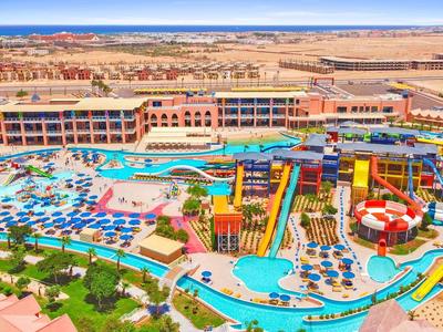 Großer Wasserpark mit bunten Wasserrutschen, Pools, Sonnenschirmen und einem weitläufigen Hotelkomplex.