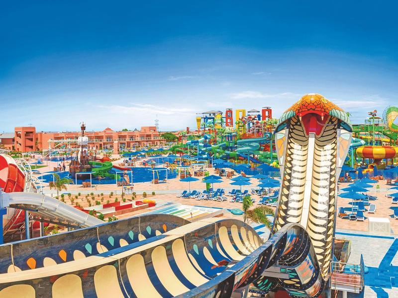 Colorful water park with slides and multiple pools under a blue sky.