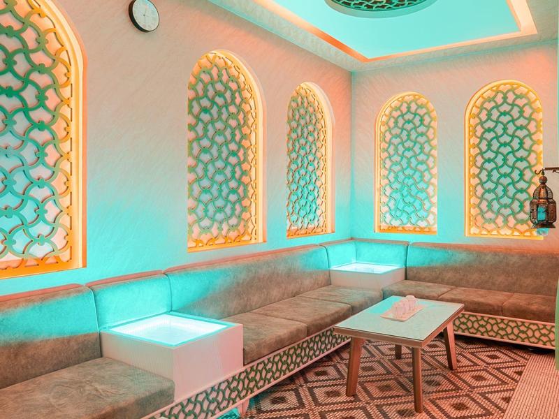 Modern lounge room with geometric lighting and cozy seating bench