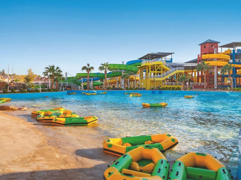 View of a water park with wave pool, water slides, and inflatable swim rings.