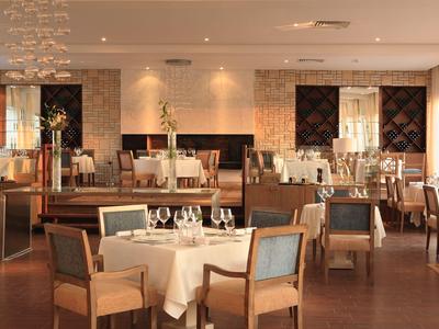 Ristorante elegante con tavoli apparecchiati e sedie di legno in un'atmosfera calda.