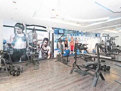 Modern gym with workout equipment and large wall murals in a hotel.