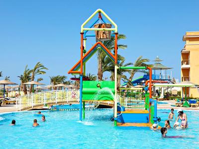 Colorful water playground with slides and children in a hotel pool under a sunny sky.