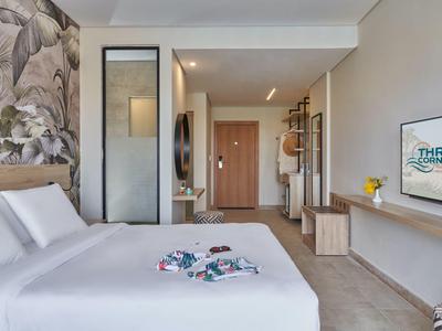 Modernes Hotelzimmer mit großem Bett, Blumendekor an der Wand und Flachbildschirm.