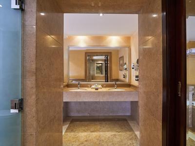View through a bathroom doorway showing a countertop with two sinks and a large mirror.