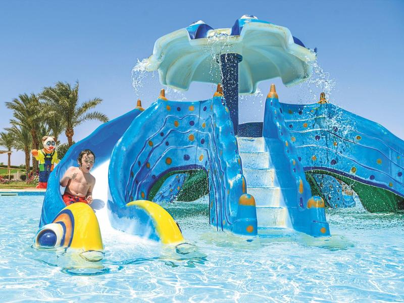 Water park with slides and splash pool under clear blue sky