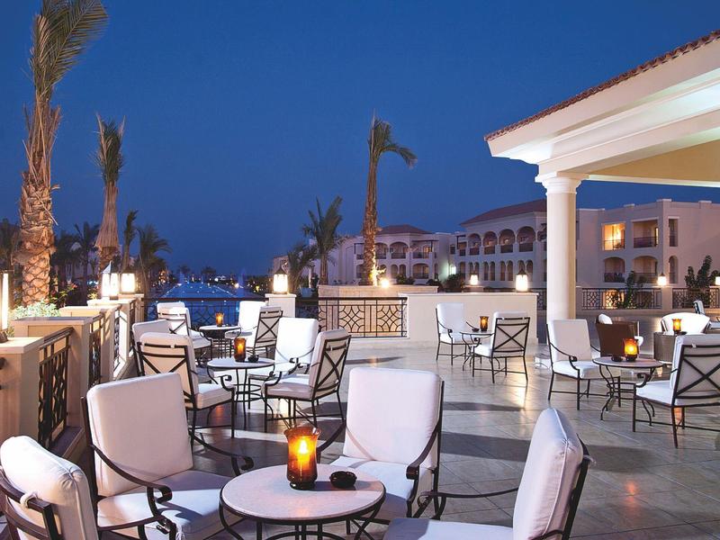 Gemütliche Terrassenmöbel mit Beleuchtung auf einer Dachterrasse bei Nacht unter klarem Himmel.