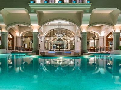 Oświetlony kryty basen z kolumnami i łukami w luksusowym hotelu