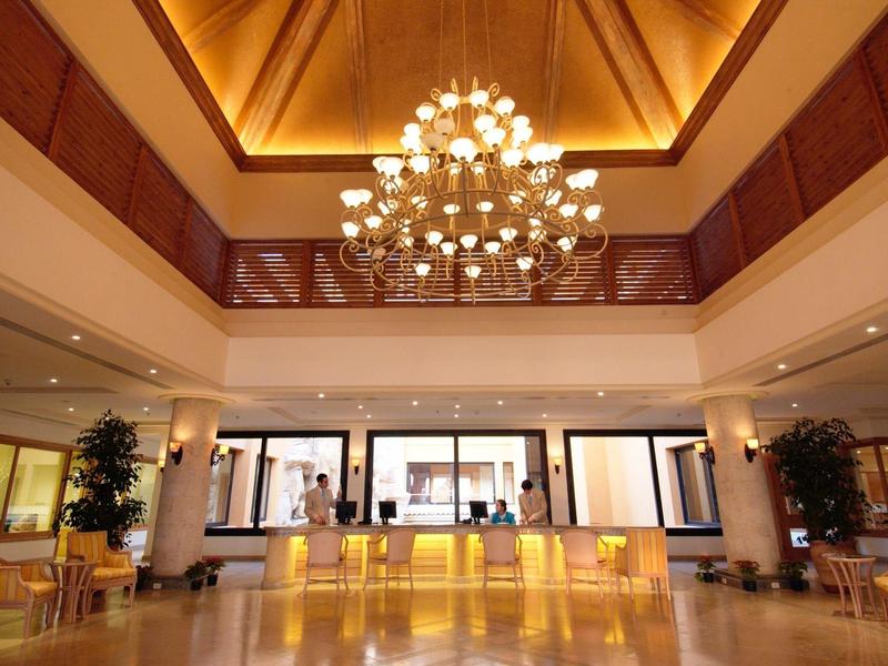 Spacious hotel lobby with impressive chandelier lighting and a reception desk.