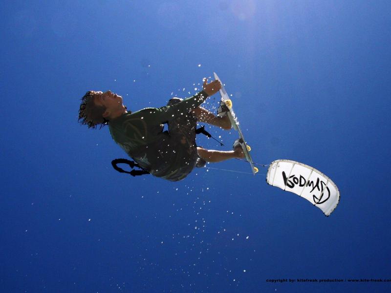 Person wakeboarding over blue water in sunny weather