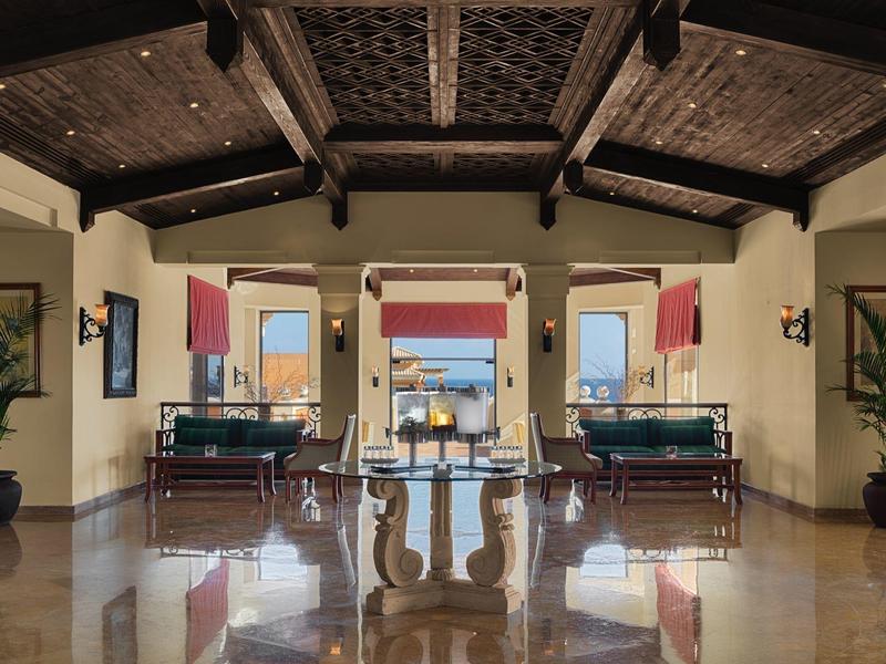 Elegant hotel lobby with leather armchairs, large vases, and polished marble floor.