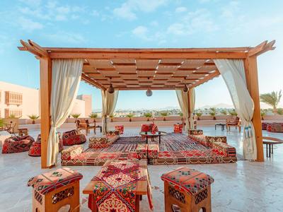 Padiglione aperto con tappeti e cuscini in una zona di resort soleggiata